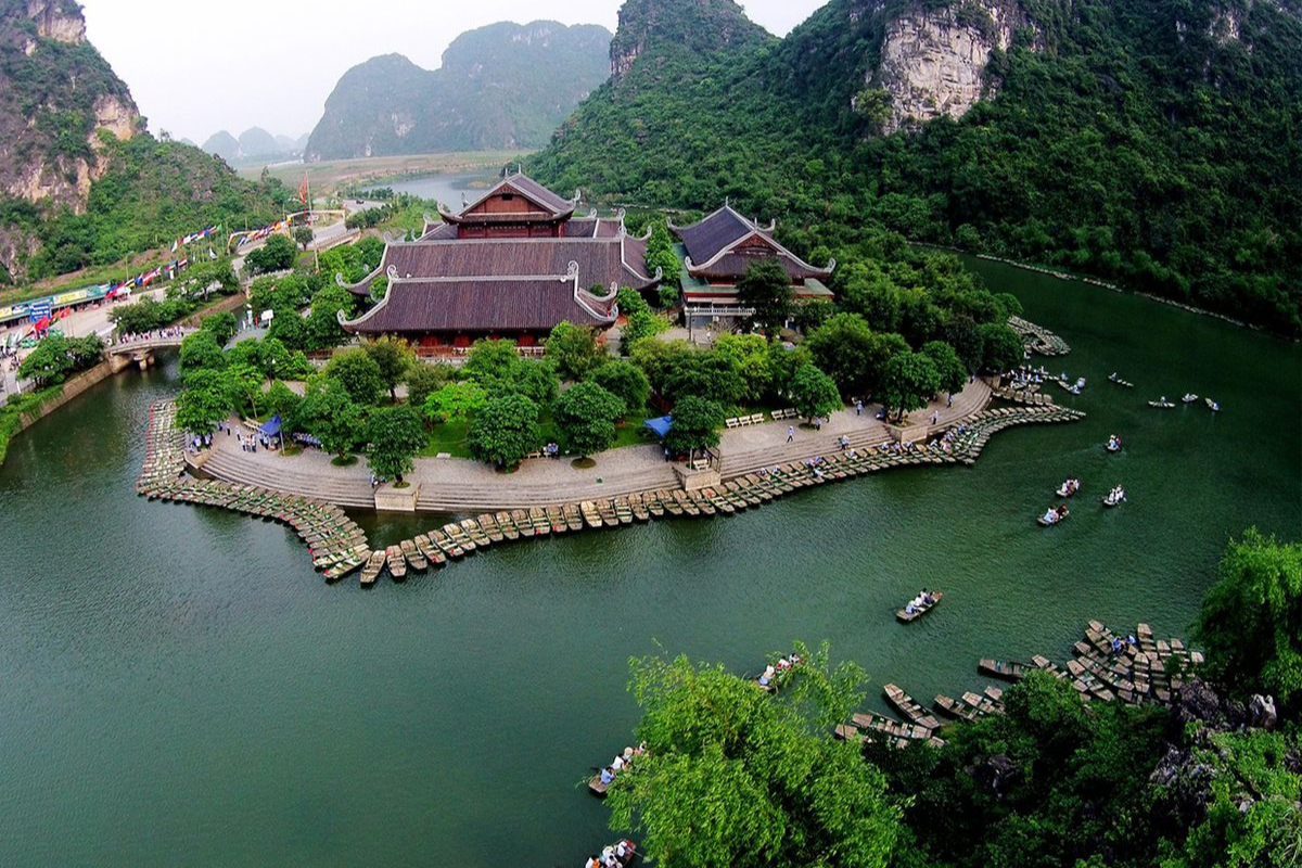 游客乘船穿梭于长安生态旅游区的河流、洞穴和石灰岩山峰之间，欣赏世界自然遗产的壮丽景色 